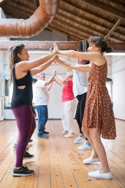 Neşeli genç Kafkasyalı eğitmen son sınıflarla dans ediyor.