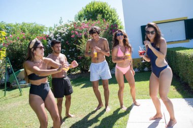 Mutlu arkadaşlar arka bahçede parti yapıyor.