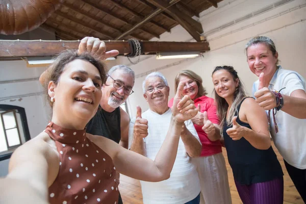 Mutlu son sınıf dans grupları stüdyoda başparmak kaldırıyor.