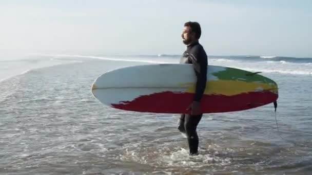 Largo tiro de surfista estable con la pierna biónica va a la orilla — Vídeos de Stock