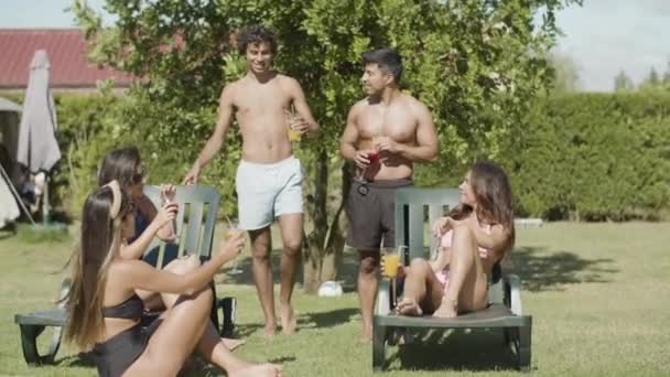 Homens e mulheres bonitos em trajes de banho óculos clinking no quintal — Vídeo de Stock