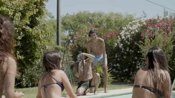 Vorderansicht von Jungs, die Mädchen im Bikini vor der Kamera fotografieren — Stockvideo