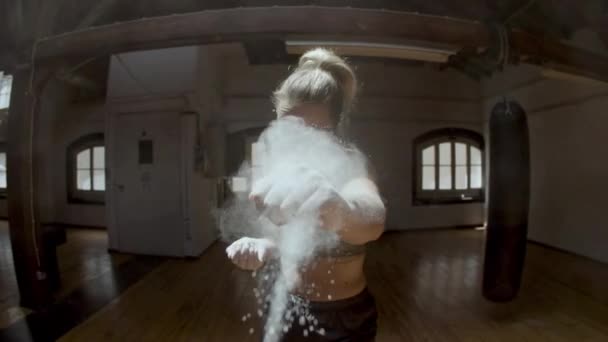 Žena punching na kameru s rukou povlak v křídovém prášku — Stock video