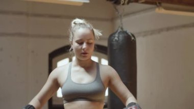 Boks eldivenli kadın boksör spor salonunda dikiliyor.