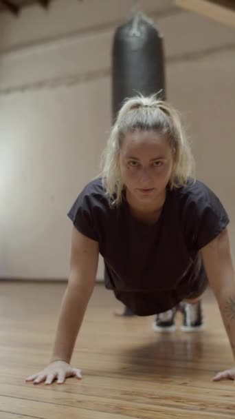 Tiro vertical de la mujer de pie en posición de tablón en el gimnasio — Vídeo de stock