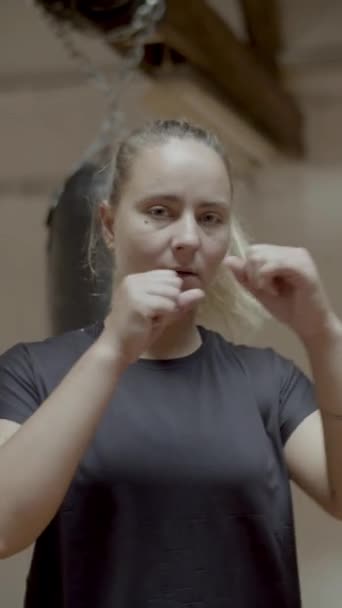 Verticaal schot van vrouwelijke kickbokser voorbereiding voor training — Stockvideo