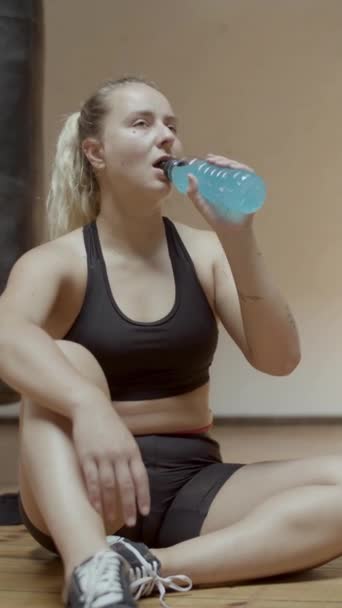 Widok z przodu kobiety sportowca pijącej izotoniczne po treningu — Wideo stockowe