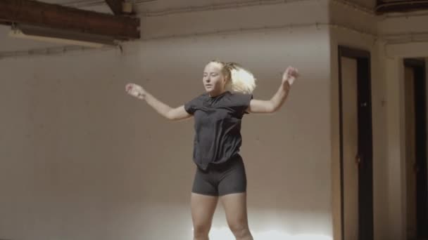 Slow motion van jonge vrouw doen springen jacks in sportschool — Stockvideo