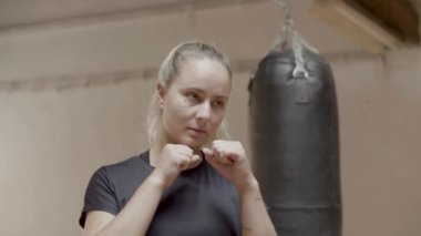 Kendine güvenen bayan boksörün orta boy vuruşu.