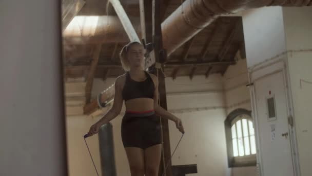 Střední záběr krásné ženy skákání provaz sám v tělocvičně — Stock video