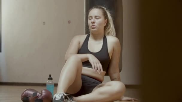 Vista frontal do atleta exausto bebendo isotônico no ginásio — Vídeo de Stock