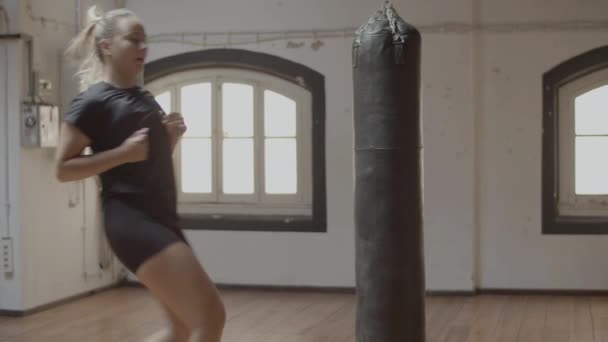 Spor salonunda dizleri yükseklerde koşan kadın boksörün yan görünüşü — Stok video