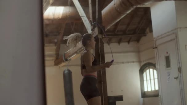 Zijaanzicht van atletische vrouw springtouw in de oefenruimte — Stockvideo