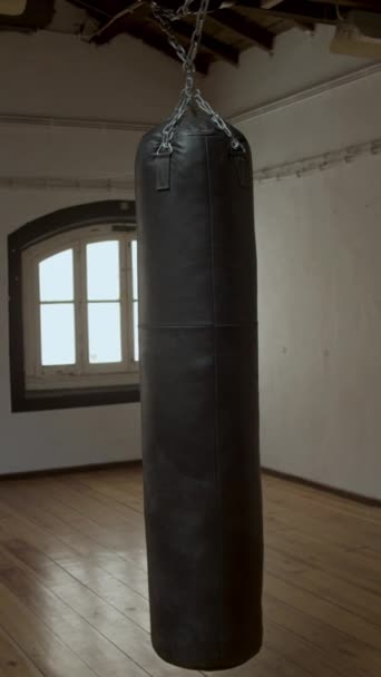 Vertikální záběr houpacího hnědého boxovacího pytle v prázdné tělocvičně — Stock video