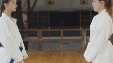 Antrenmana başlamadan önce boyun eğen dövüş sanatçılarının yan görünümü