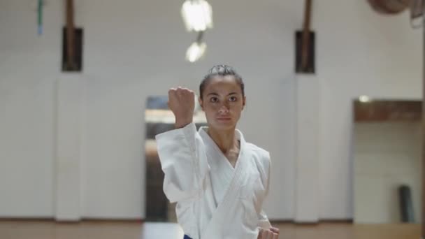 Widok z przodu poważnej dziewczyny wykonującej podstawowe pozycje karate — Wideo stockowe