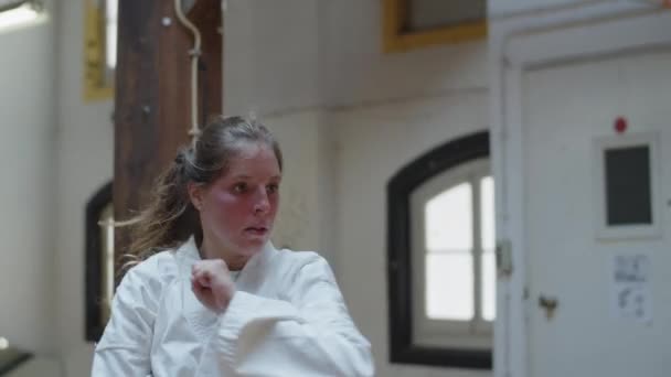 Handheld shot van gerichte karateka doen jump kicks op camera — Stockvideo