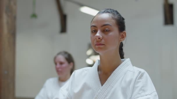 Close-up shot van karateka glimlachen op de camera tijdens het zitten in de sportschool — Stockvideo