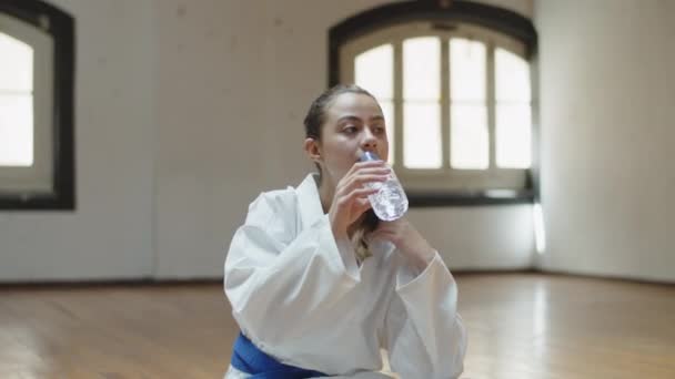 Előnézet vidám lány ivóvíz karate edzés után