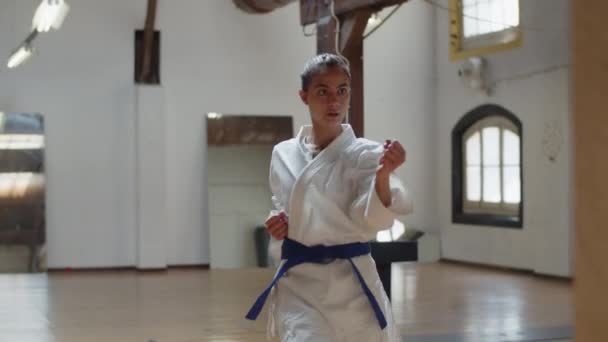 Medium skott av karateka lungor och sparkar i övningsrummet — Stockvideo