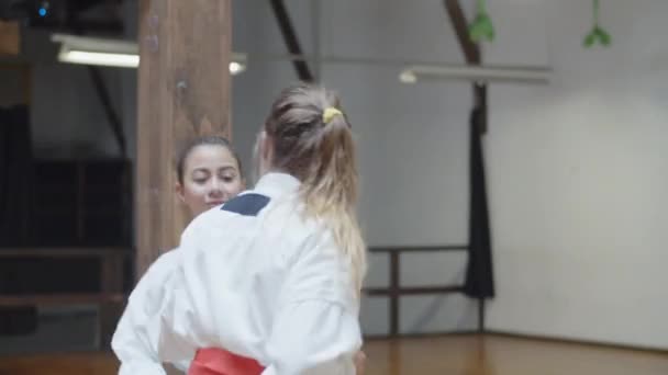 Tiro de mão de meninas felizes praticando karatê juntos no ginásio — Vídeo de Stock