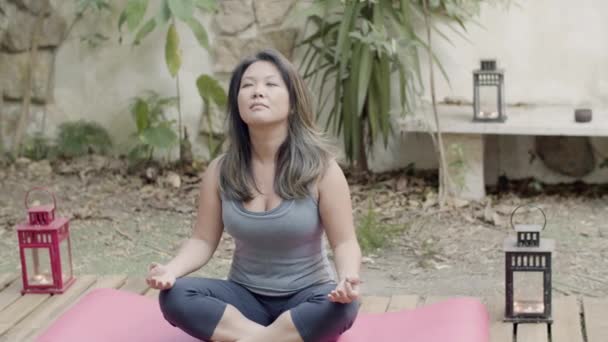 Långskott av bekymmerslös japansk kvinna mediterar i trädgården — Stockvideo