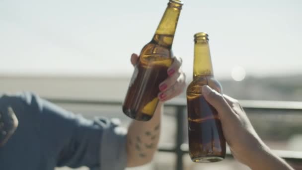 Lidé cinkající láhve piva, když mají párty na střeše — Stock video