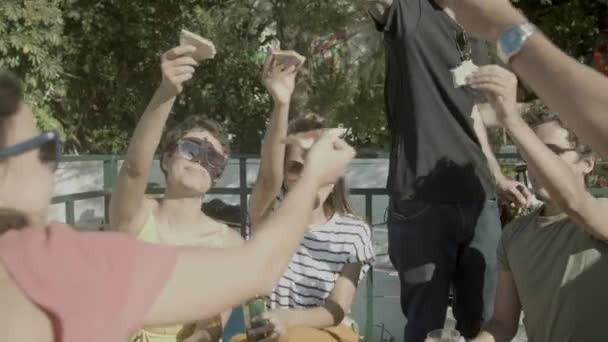 Hombres y mujeres felices criando rebanadas de pizza durante la fiesta al aire libre — Vídeo de stock