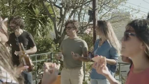 Beztroscy przyjaciele stojący na dachu, mówiący i jedzący pizzę — Wideo stockowe