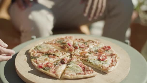 Ludzie biorący kawałki świeżo upieczonej pizzy ze stołu — Wideo stockowe