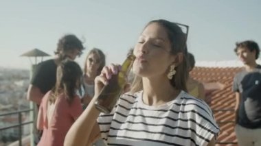 Mutlu İspanyol kadın bira içiyor ve çatıda pizza yiyor. 