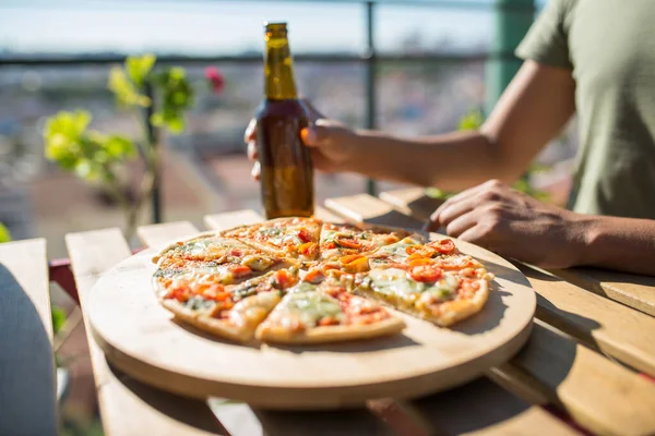 Primer plano de la pizza y la botella de cerveza en la mesa — Foto de Stock