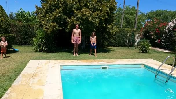 Neşeli erkek gençler yüzme havuzuna atlıyorlar. — Stok video