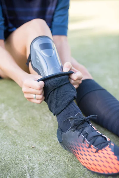 Close-up of young woman getting ready for football training