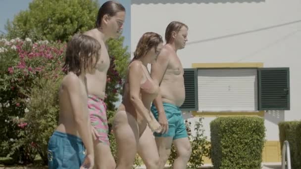 Weseli rodzice i dzieci biegający razem do basenów — Wideo stockowe
