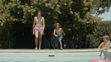 Heyecanlı çocuklar birlikte yüzme havuzuna giriyorlar.