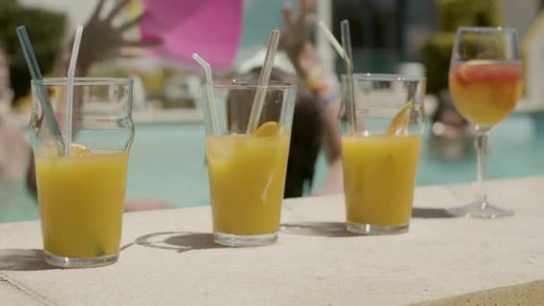 Naranja bebidas refrescantes en el lado de la piscina — Vídeos de Stock