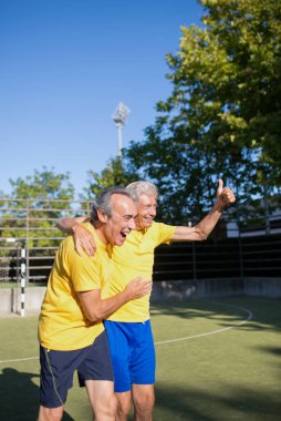 Mutlu son sınıflar güneşli bir günde futbol oynuyor.