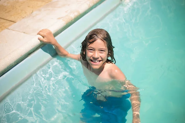 Mutlu çocuk yüzme havuzunda yüzüyor — Stok fotoğraf