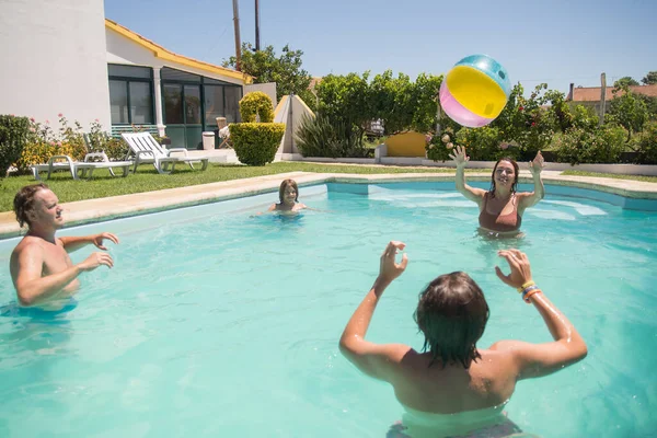 Mutlu aile yüzme havuzunda top oynuyor