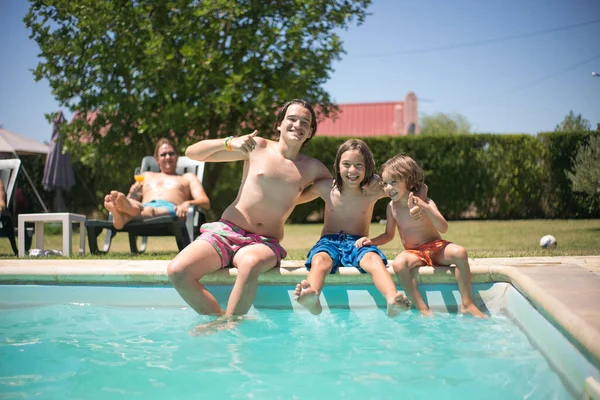 Yüzme havuzunun yanında eğlenen mutlu kardeşlerin portresi. — Stok fotoğraf