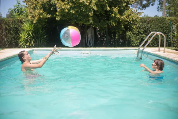 Radostní bratři hrají fotbal v bazénu Stock Snímky