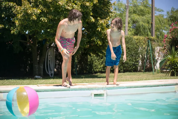 Radostní bratři plavající v bazénu Stock Snímky