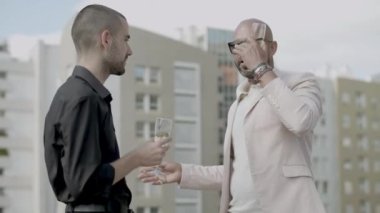 Neşeli iş ortakları şampanya içip sohbet ediyorlar.