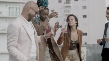 Mutlu çalışanlar şampanya ve açık havada dans ederek kadeh kaldırıyor.