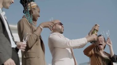 Mutlu çalışanlar şampanyayı parti sırasında şapırdatarak açıyor.