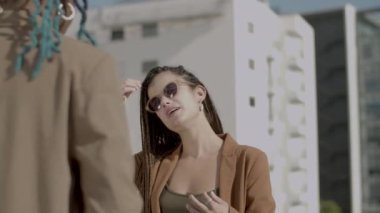 Gülümseyen kadın dışarıda iş arkadaşıyla konuşuyor.