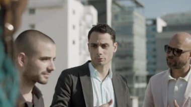 İş ortaklarının çatıda dikilip konuştuğu orta boy bir fotoğraf.