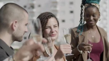 Dışarıda şampanyayla kadeh kaldıran heyecanlı meslektaşlarımızın yan görüntüsü.