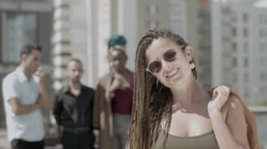 Neşeli iş kadını çatıda dikilip kameraya bakıyor. 